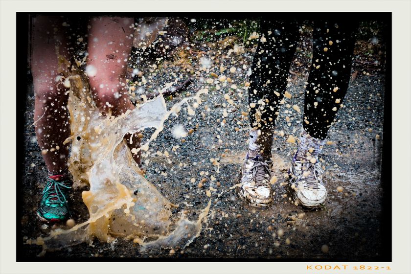 mud splashing onto the shoes and legs of two people
